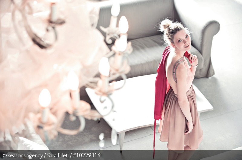 Frau im Rock blickt nach oben, Oberteil rückenfrei